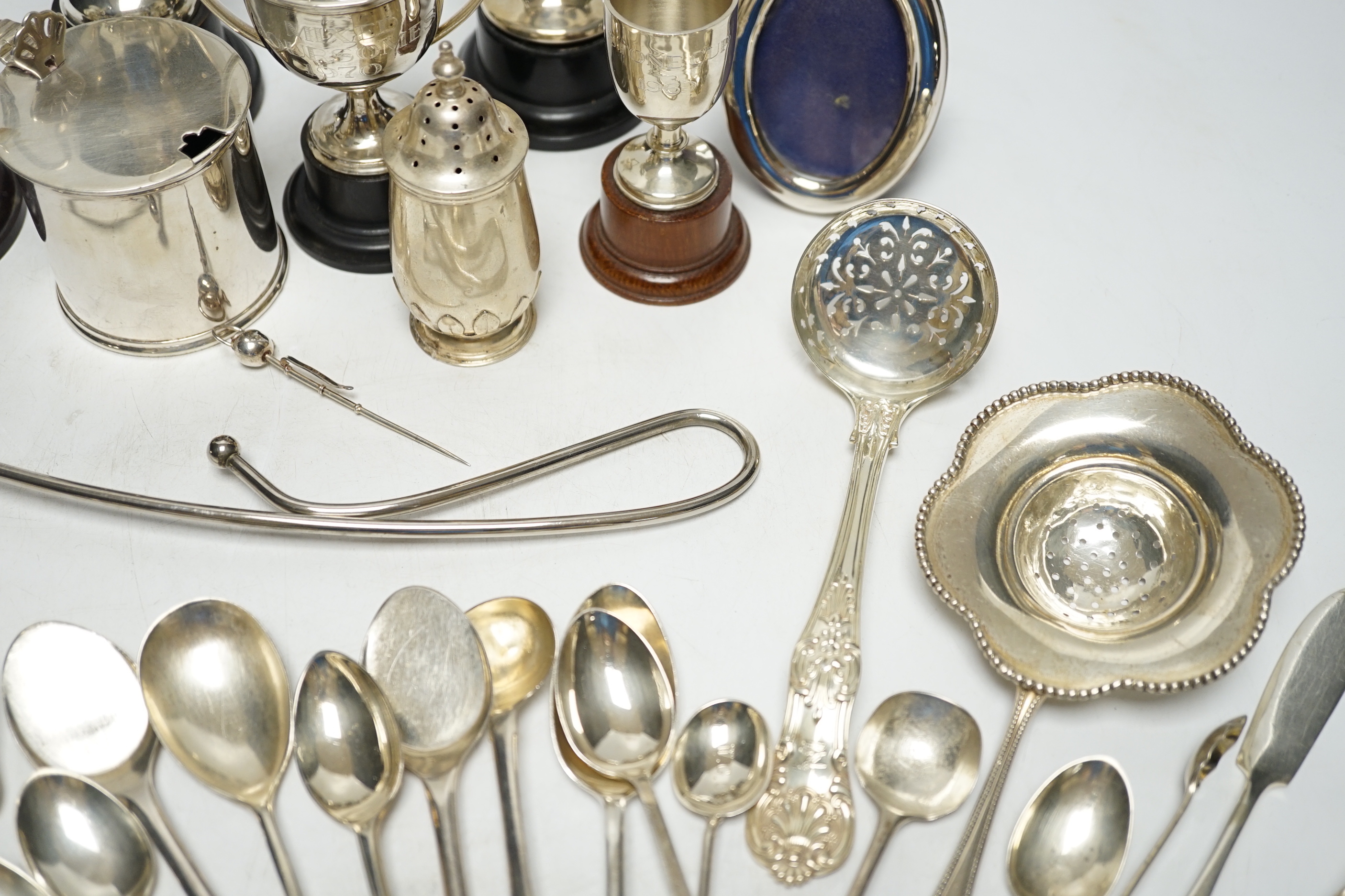 Sundry minor silver flatware including a Victorian Kings pattern sifter ladle, a silver mustard pot and pepperette, four small silver trophy cups and two other items.